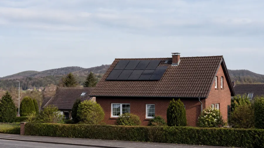 Photovoltaikanlage auf dem Dach eines norddeutschen Klinker-Einfamilienhauses, von der Straße aus gesehen.